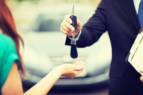 car-salesman-handing-keys-to-female-driver-teaser