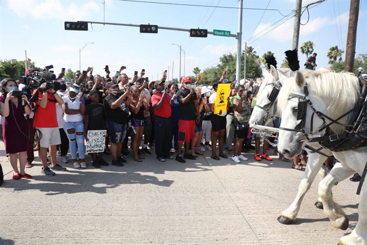 HOUSTON, TEXAS - JUNE 09: People watch as the horse drawn hearse containing the remains of George Floyd makes its way to the Houston Memorial Gardens cemetery on June 9, 2020 in Houston, Texas. Floyd died May 25 while in Minneapolis police custody, sparking nationwide protests. Joe Raedle/Getty Images/AFP